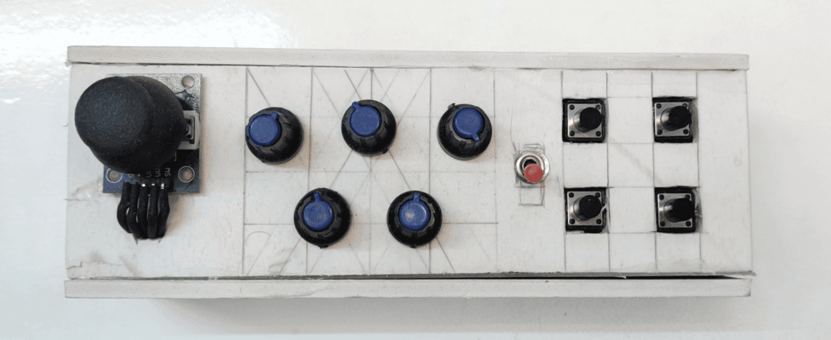 The finished controller: joystick, five knobs, power LED and a 2×2 key grid in a white foam-board case
