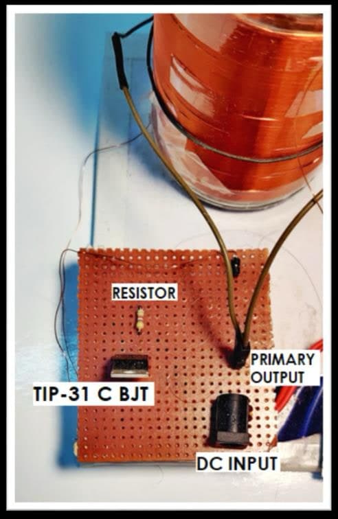 The exciter on perfboard: TIP-31C BJT, base resistor, DC input jack and the primary winding leads